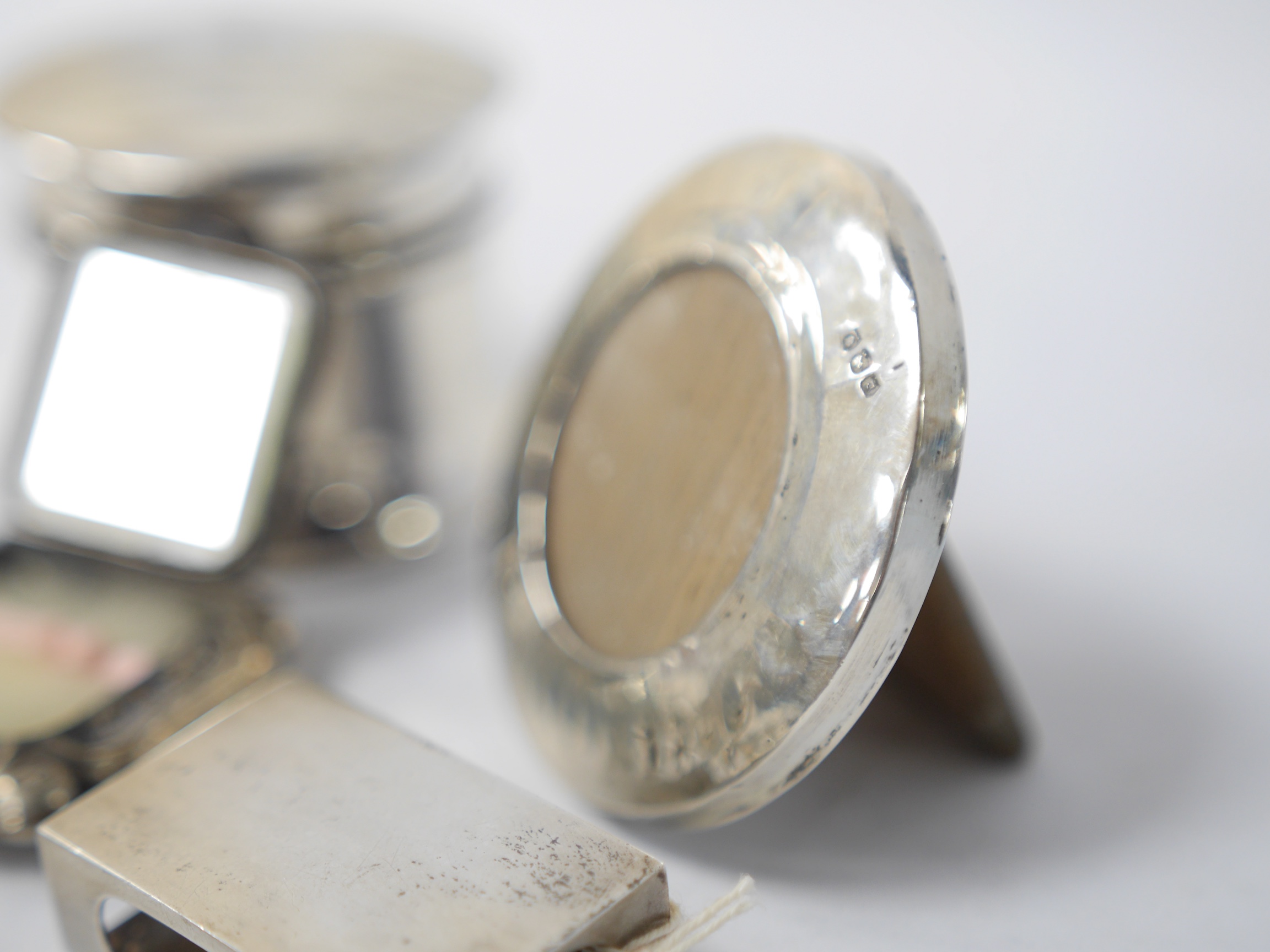 Assorted small collectables including a late Victorian silver vesta case, Birmingham, 1898, a small silver mounted circular photograph frame, a silver mounted glass pot and cover, a silver matchbox sleeve and three other